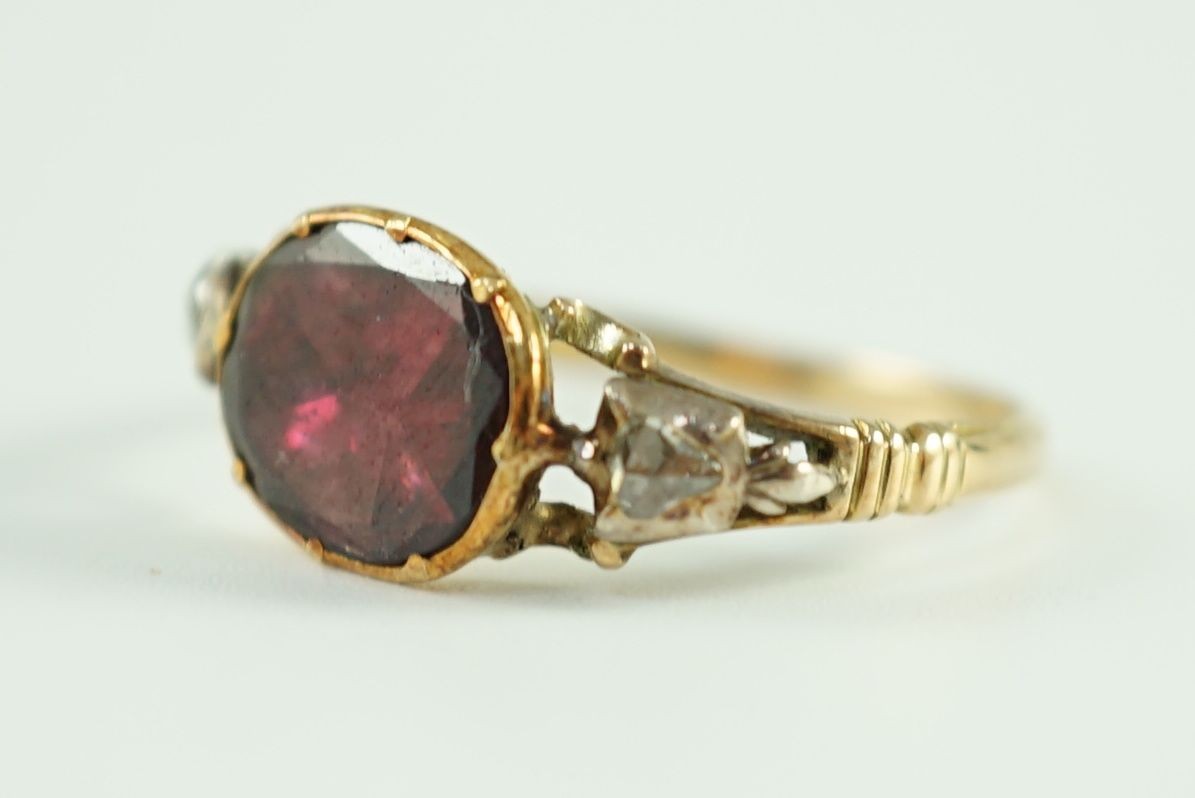 A George III gold, foil backed garnet and rose cut diamond set three stone ring